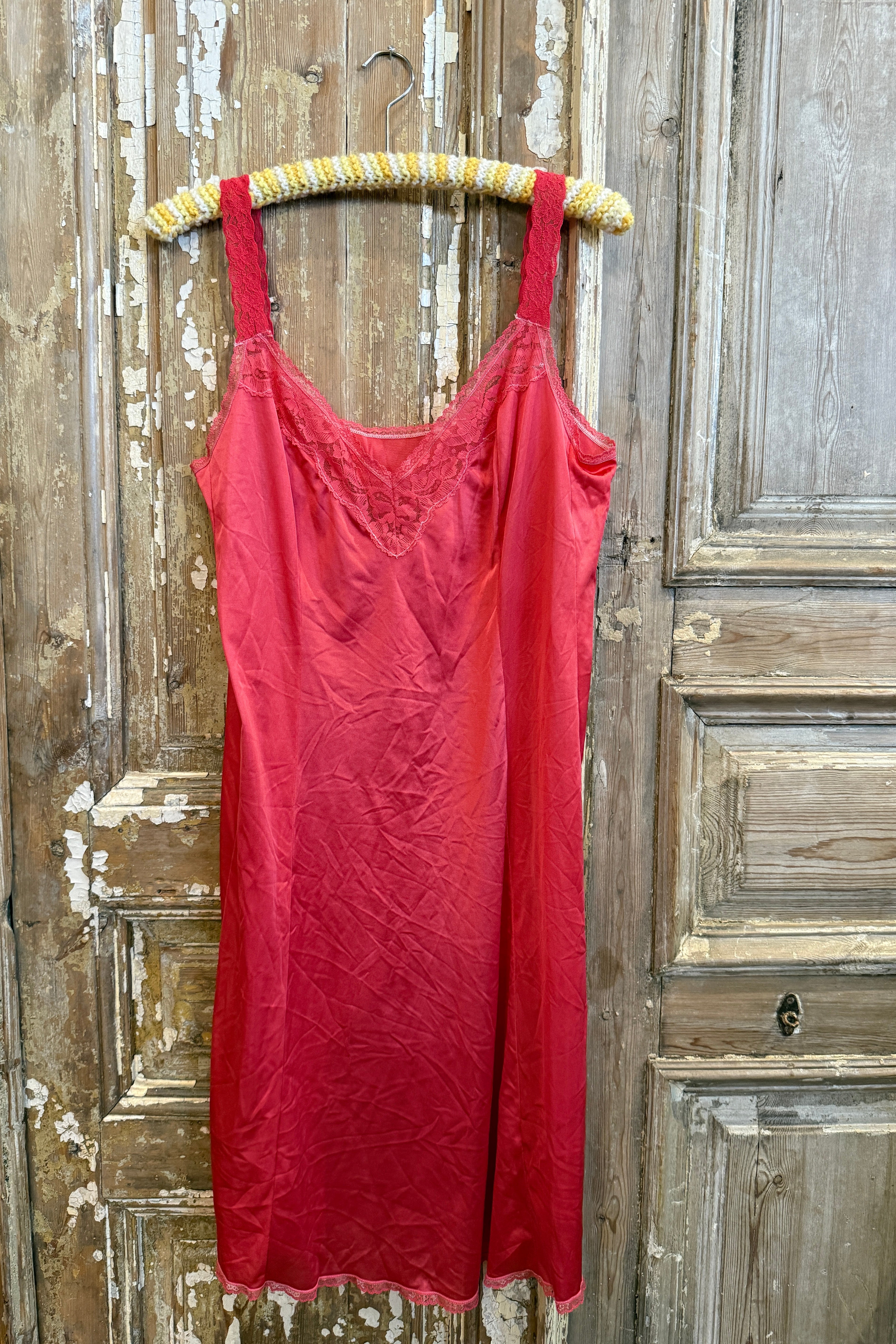 Red dress on a wooden surface with a decorative belt